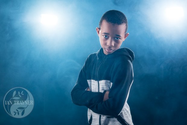 Cool photo of boy with smoke and lights from behind. He is showing some attitude.