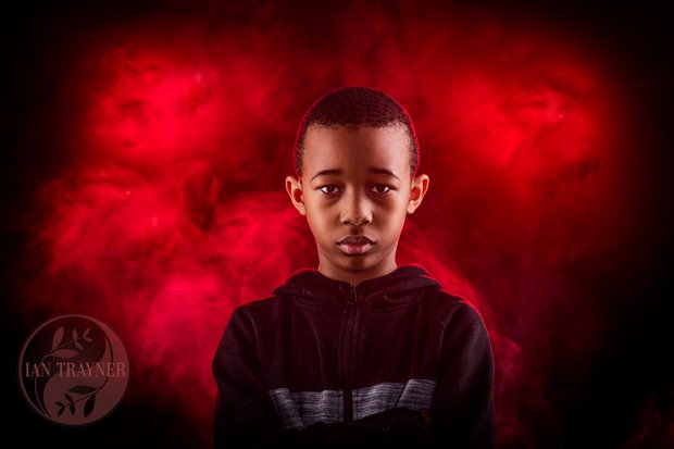 cool photo of boy using smoke and lights with red gels
