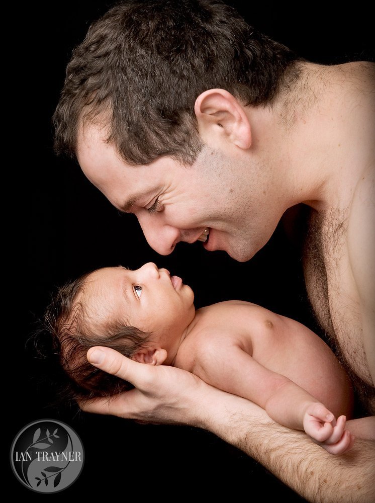 Baby photo shoot. Very proud father looking into his baby's eyes.